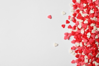 Bright heart shaped sprinkles on white background, flat lay. Space for text Photo of Bright heart shaped sprinkles on white background, flat lay. Space for text