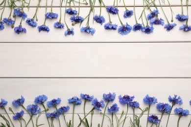 Frame of beautiful blue cornflowers on white wooden background, flat lay. Space for text Photo of Frame of beautiful blue cornflowers on white wooden background, flat lay. Space for text