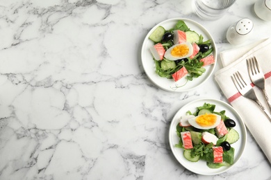 Delicious crab stick salad served on white marble table, flat lay. Space for text Photo of Delicious crab stick salad served on white marble table, flat lay. Space for text