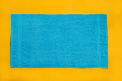 Light blue beach towel on yellow background, top view Photo of Light blue beach towel on yellow background, top view