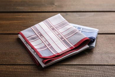 Handkerchiefs with patterns folded on wooden table Photo of Handkerchiefs with patterns folded on wooden table