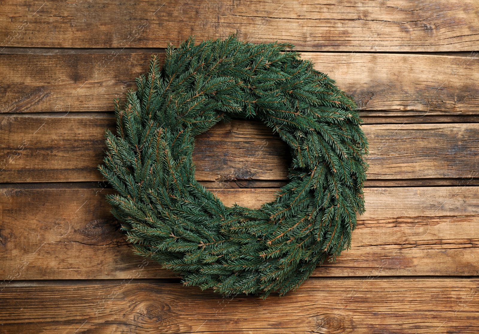 Christmas wreath made of fir branches on wooden background, top view Photo of Christmas wreath made of fir branches on wooden background, top view