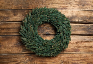 Christmas wreath made of fir branches on wooden background, top view Photo of Christmas wreath made of fir branches on wooden background, top view