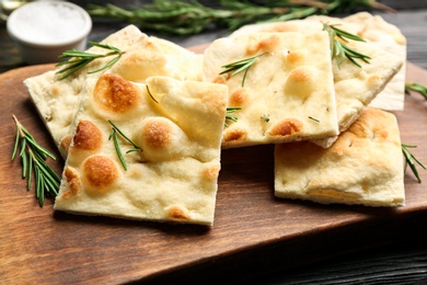 Delicious focaccia bread on wooden board, closeup Photo of Delicious focaccia bread on wooden board, closeup