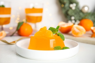 Delicious tangerine jelly with mint on white table Photo of Delicious tangerine jelly with mint on white table