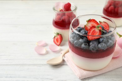 Delicious panna cotta with berries on white wooden table. Space for text Photo of Delicious panna cotta with berries on white wooden table. Space for text
