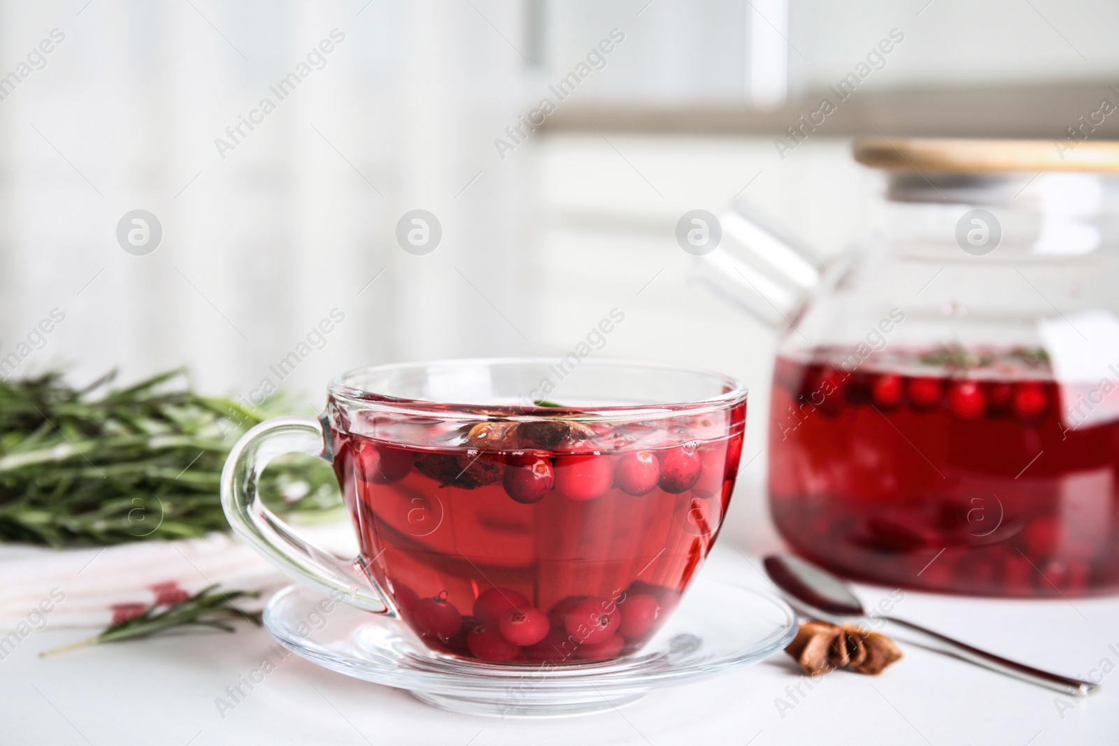 Tasty hot cranberry tea on white table Photo of Tasty hot cranberry tea on white table