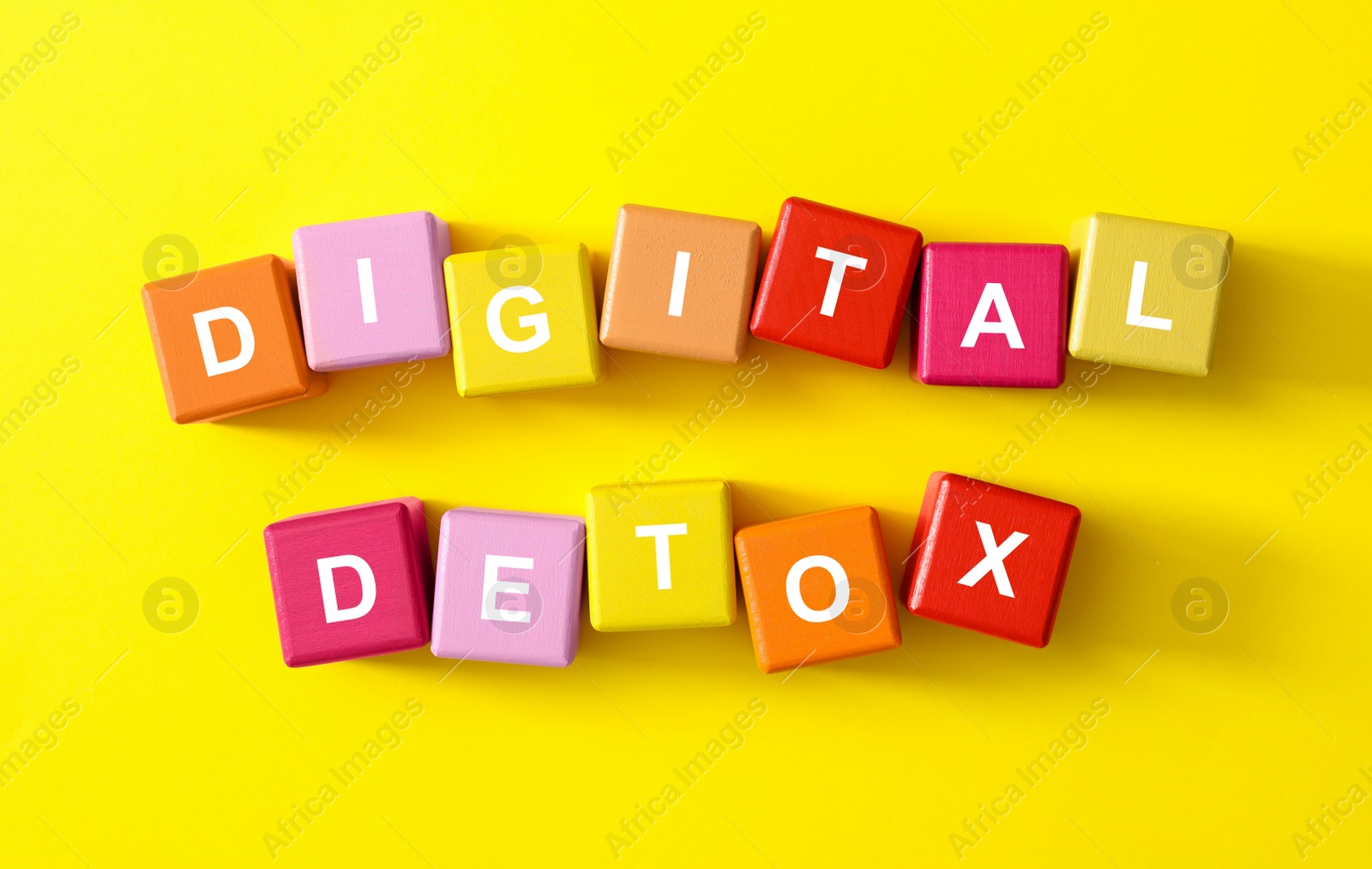 Colorful cubes with phrase DIGITAL DETOX on yellow background, flat lay Photo of Colorful cubes with phrase DIGITAL DETOX on yellow background, flat lay