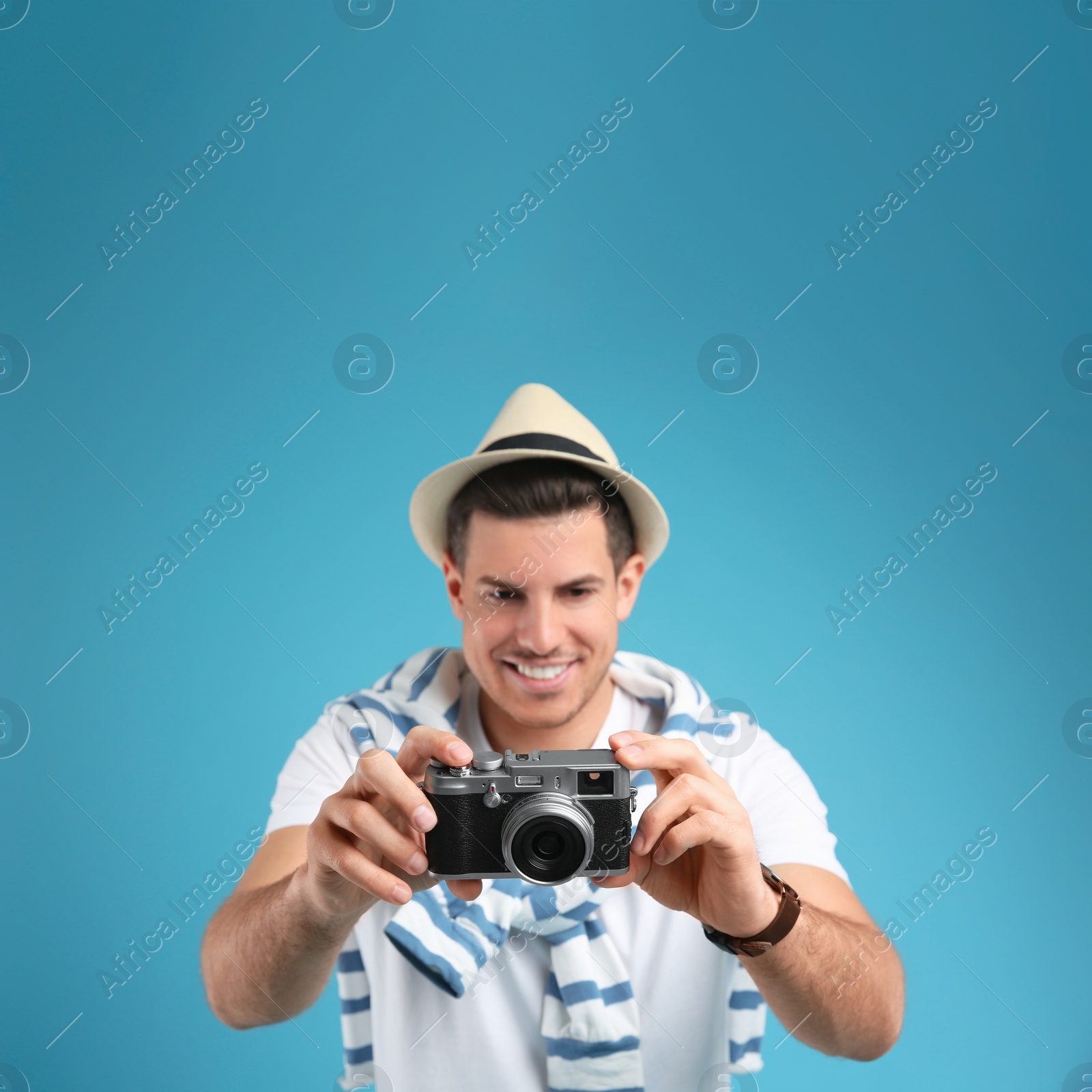 Male tourist taking picture against turquoise background, focus on camera Photo of Male tourist taking picture against turquoise background, focus on camera