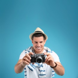Male tourist taking picture against turquoise background, focus on camera Photo of Male tourist taking picture against turquoise background, focus on camera