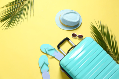 Photo of Flat lay composition with suitcase on yellow background