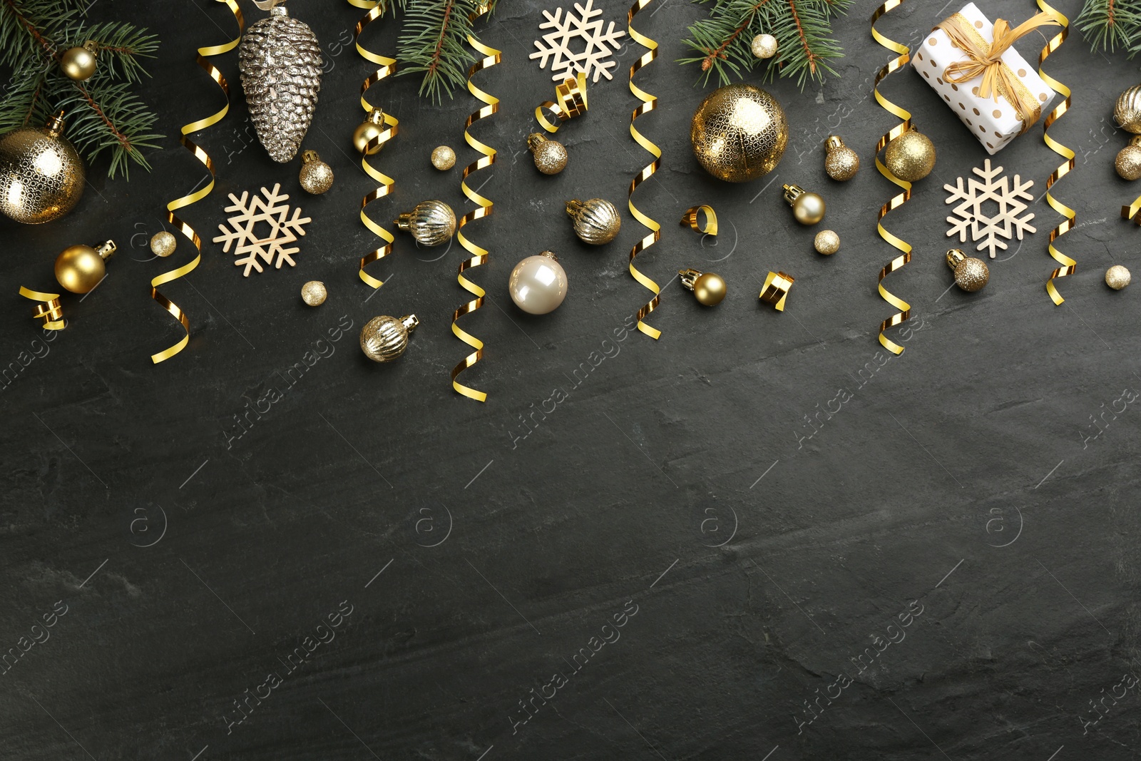 Flat lay composition with serpentine streamers and Christmas decor on black background. Space for text Photo of Flat lay composition with serpentine streamers and Christmas decor on black background. Space for text