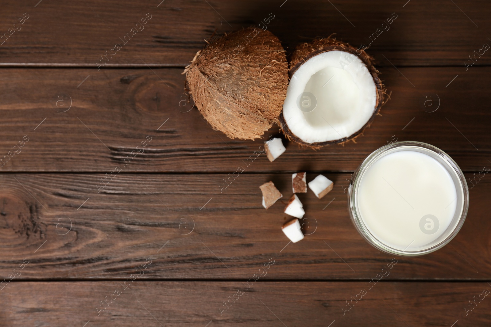 Glass of coconut milk and fresh nuts on wooden background, top view Photo of Glass of coconut milk and fresh nuts on wooden background, top view