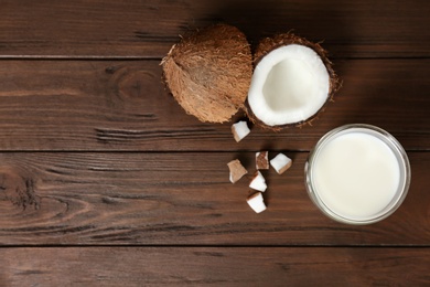 Glass of coconut milk and fresh nuts on wooden background, top view Photo of Glass of coconut milk and fresh nuts on wooden background, top view