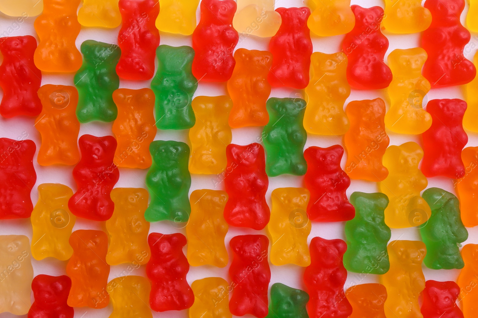 Many delicious little jelly bears on white background, flat lay Photo of Many delicious little jelly bears on white background, flat lay