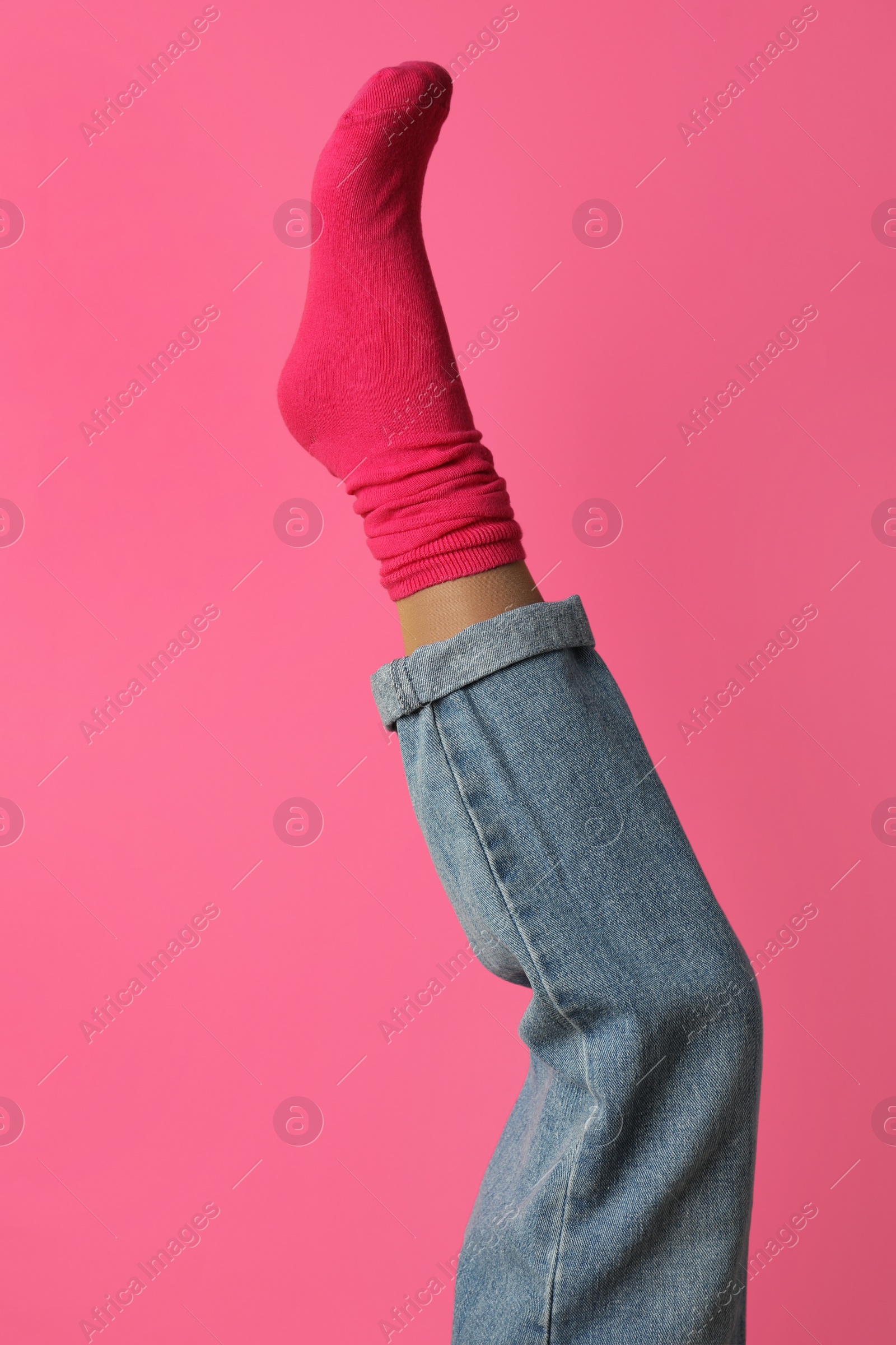 Photo of Woman wearing bright sock on pink background, closeup