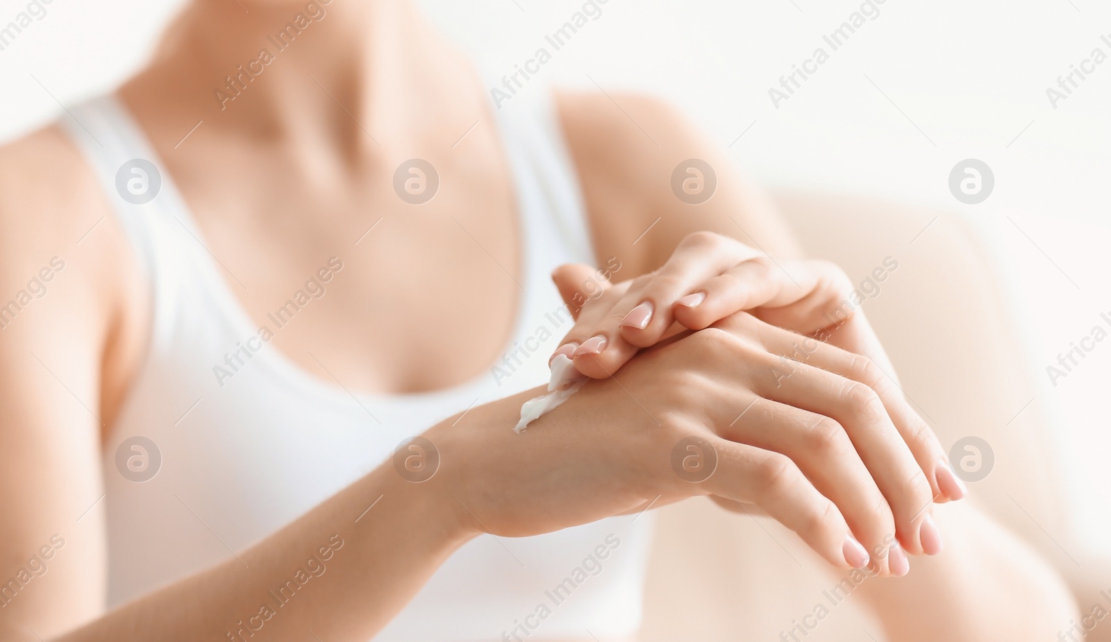 Young woman applying body cream at home Photo of Young woman applying body cream at home