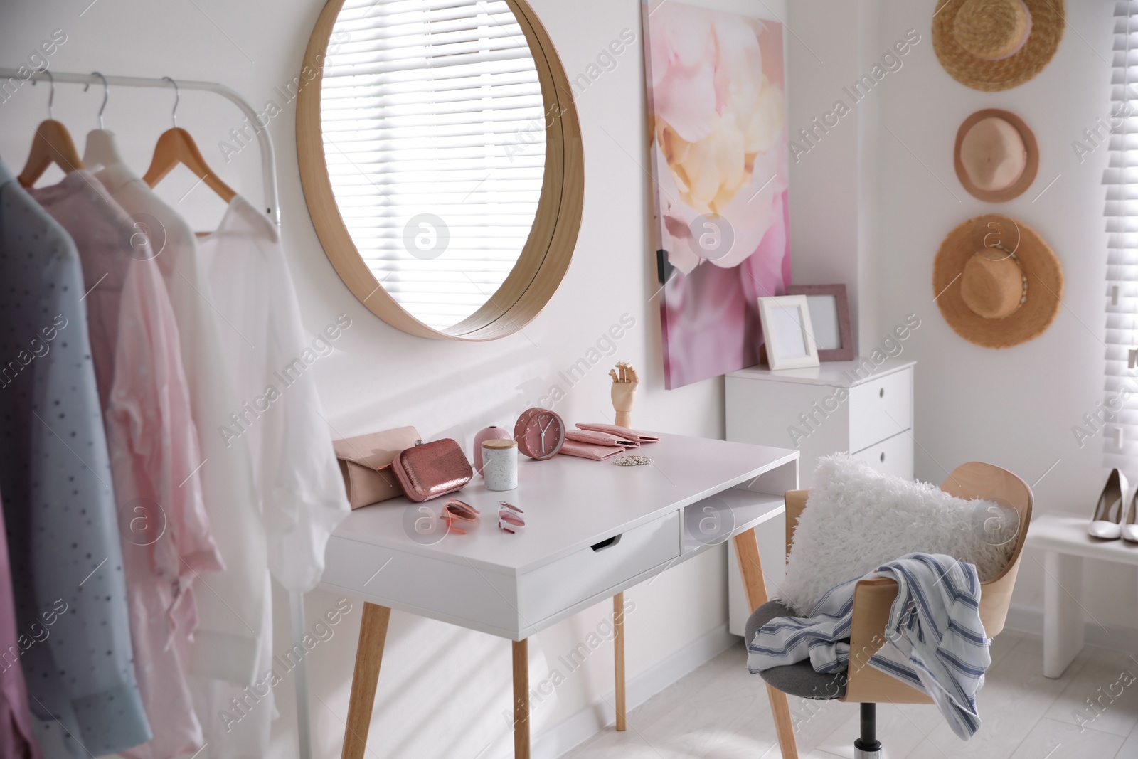 Dressing room interior with stylish makeup table, clothes and accessories Photo of Dressing room interior with stylish makeup table, clothes and accessories
