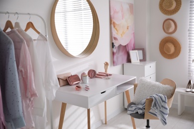 Dressing room interior with stylish makeup table, clothes and accessories Photo of Dressing room interior with stylish makeup table, clothes and accessories