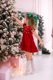 Cute little child near Christmas tree at home Photo of Cute little child near Christmas tree at home