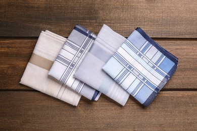Different handkerchiefs folded on wooden table, flat lay Photo of Different handkerchiefs folded on wooden table, flat lay