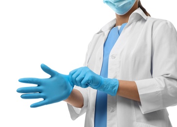Doctor in protective mask putting on medical gloves against white background, closeup Photo of Doctor in protective mask putting on medical gloves against white background, closeup