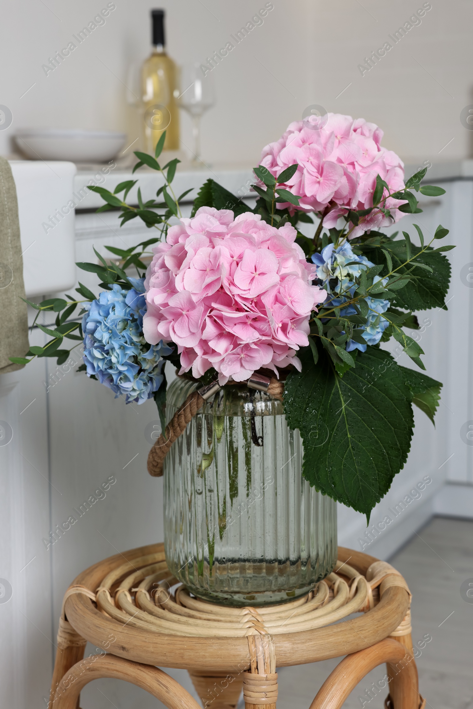 Beautiful hortensia flowers in vase on stand indoors Photo of Beautiful hortensia flowers in vase on stand indoors