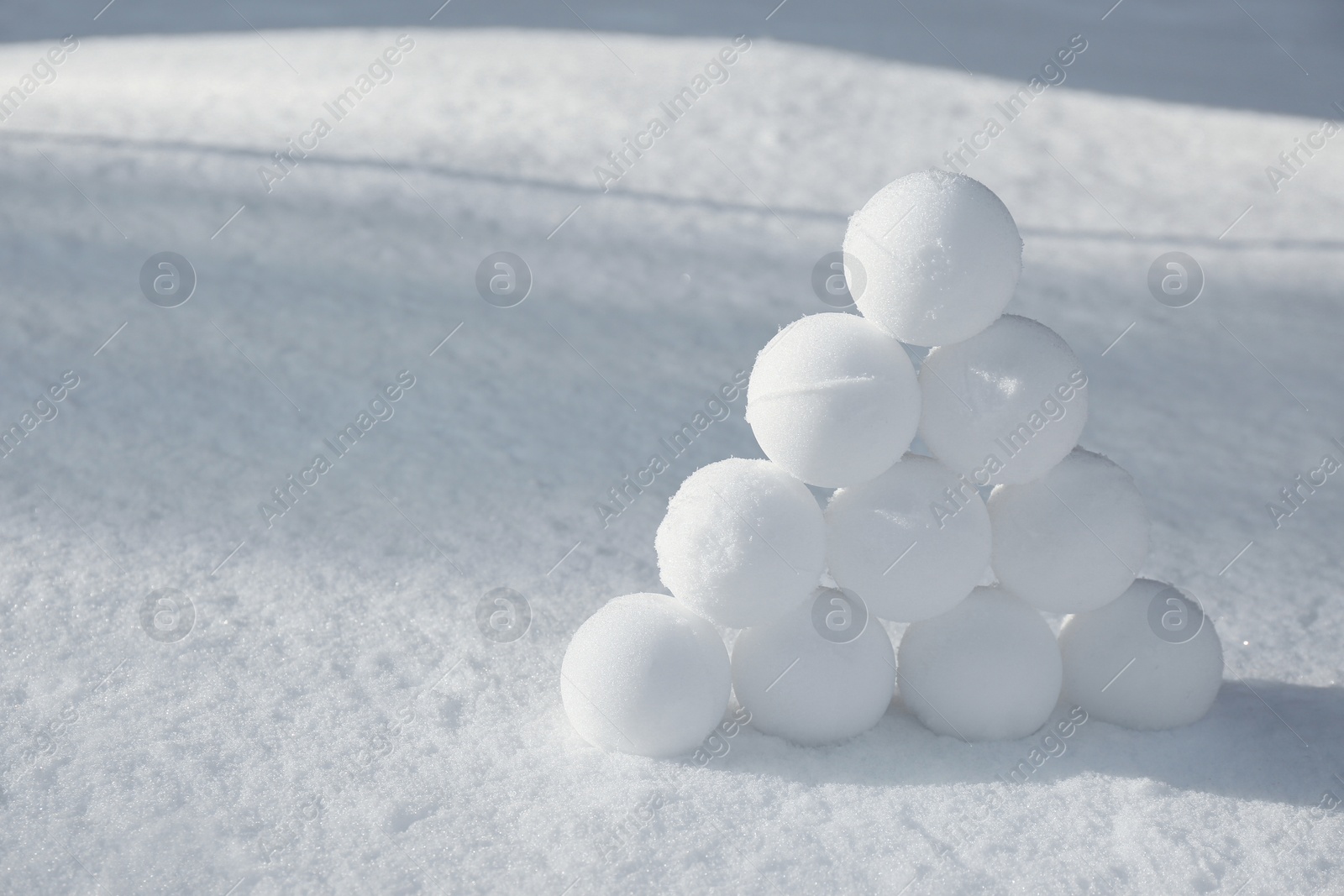 Pyramid of perfect snowballs on snow outdoors. Space for text Photo of Pyramid of perfect snowballs on snow outdoors. Space for text
