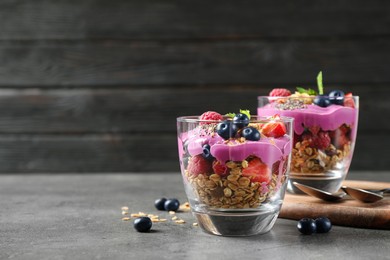 Tasty dessert with acai smoothie, granola and berries on grey table. Space for text Image of Tasty dessert with acai smoothie, granola and berries on grey table. Space for text
