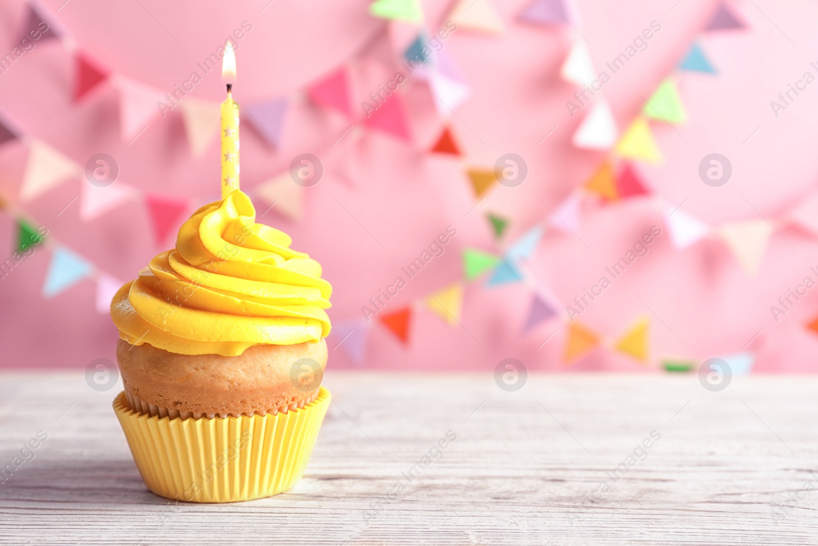 Delicious birthday cupcake with burning candle on table Photo of Delicious birthday cupcake with burning candle on table