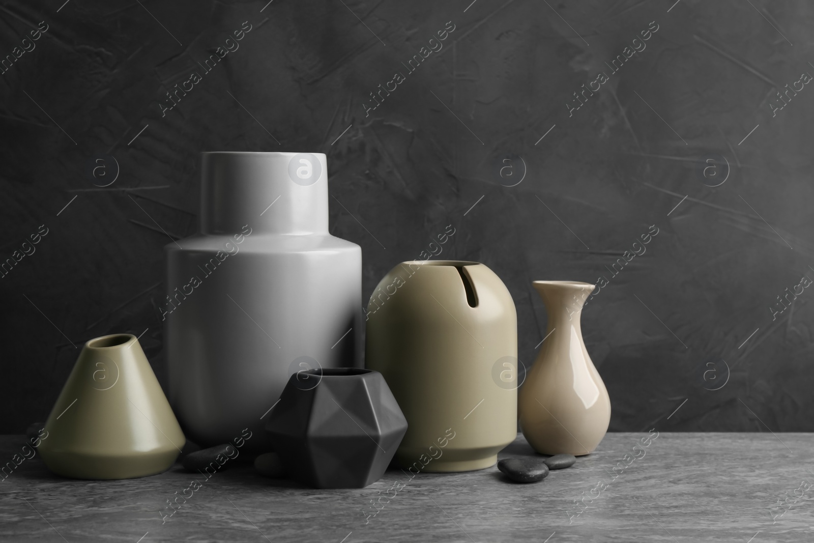 Stylish empty ceramic vases and rocks on grey table Photo of Stylish empty ceramic vases and rocks on grey table