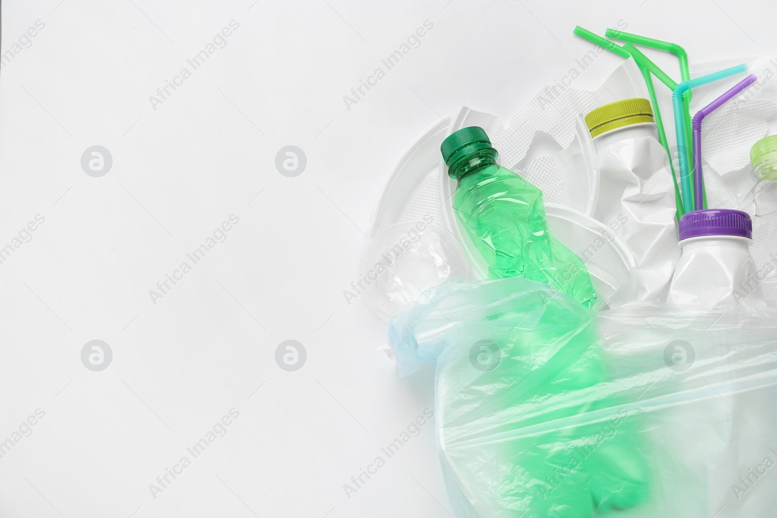 Pile of different plastic items on white background, flat lay. Space for text Photo of Pile of different plastic items on white background, flat lay. Space for text