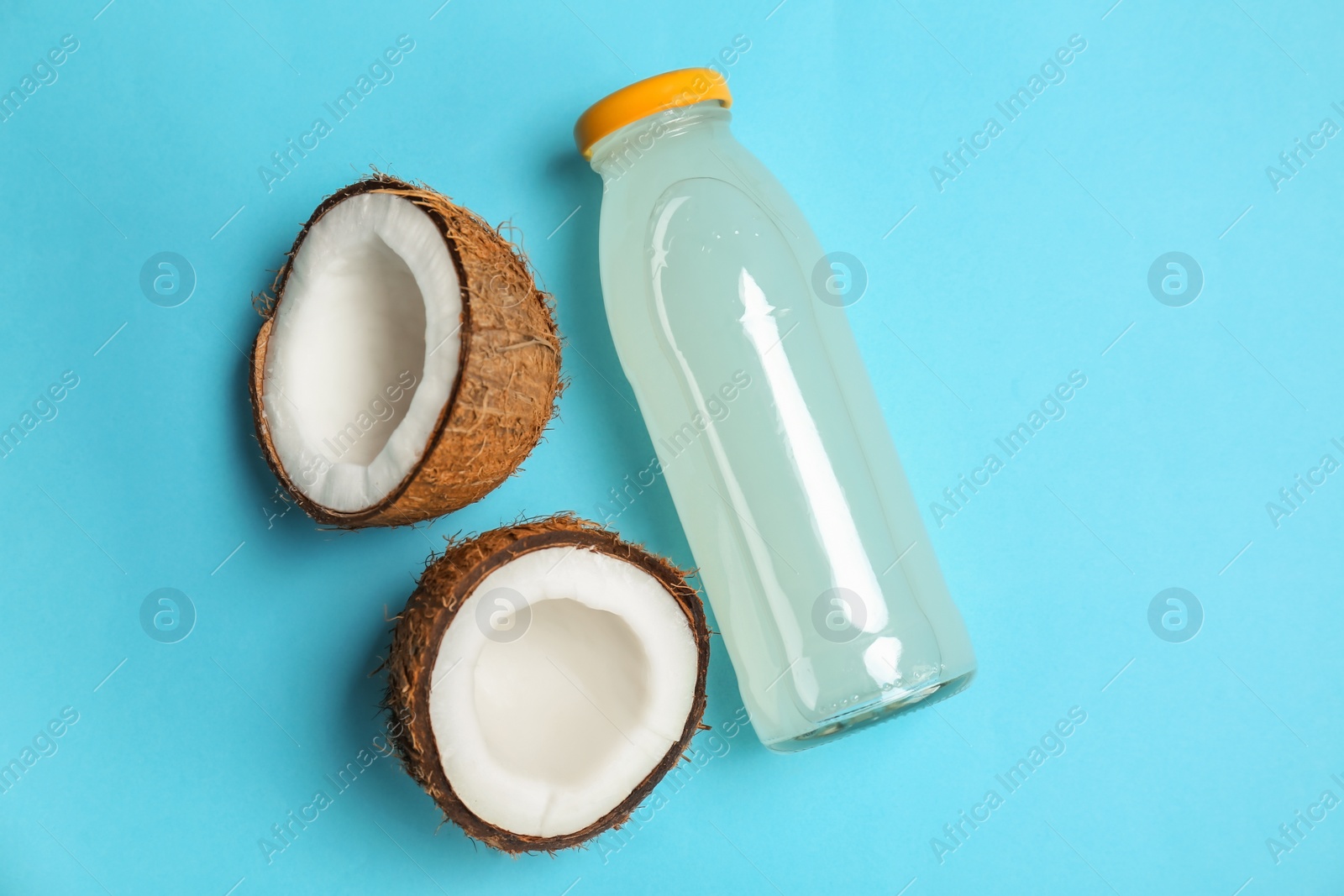 Bottle of coconut water and fresh nuts on color background Photo of Bottle of coconut water and fresh nuts on color background