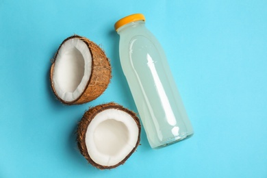 Bottle of coconut water and fresh nuts on color background Photo of Bottle of coconut water and fresh nuts on color background