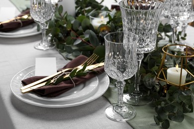 Luxury table setting with beautiful decor and blank card. Festive dinner Photo of Luxury table setting with beautiful decor and blank card. Festive dinner