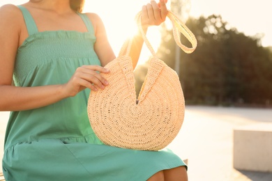 Young woman with stylish straw bag outdoors, closeup Photo of Young woman with stylish straw bag outdoors, closeup
