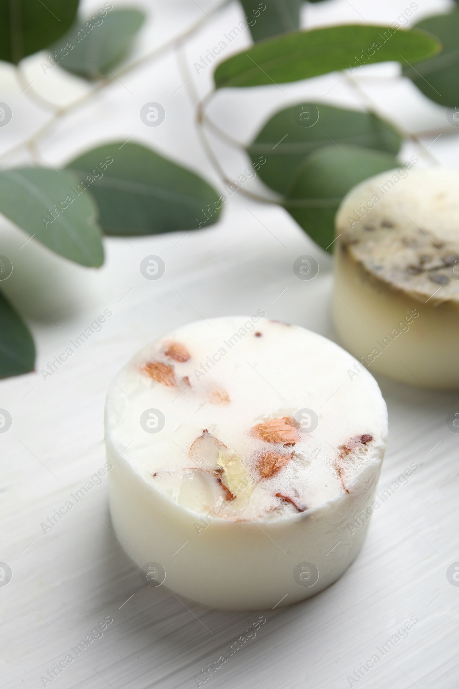 Soap bar and green leaves on white wooden table. Eco friendly personal care product Photo of Soap bar and green leaves on white wooden table. Eco friendly personal care product