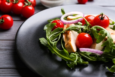 Delicious salad with chicken, vegetables and arugula on grey table, closeup Photo of Delicious salad with chicken, vegetables and arugula on grey table, closeup