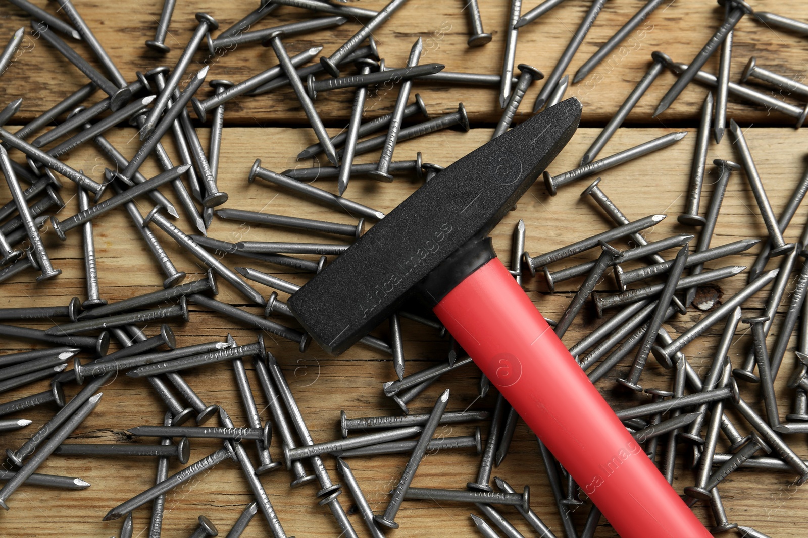 Hammer and metal nails on wooden table, flat lay Photo of Hammer and metal nails on wooden table, flat lay