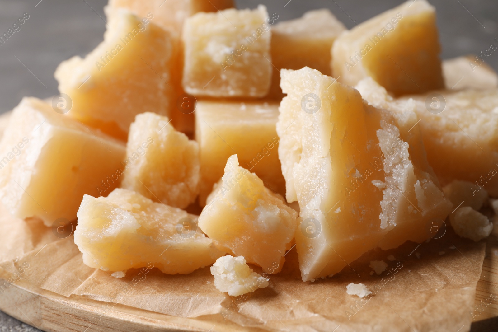 Pieces of delicious parmesan cheese on wooden board, closeup Photo of Pieces of delicious parmesan cheese on wooden board, closeup