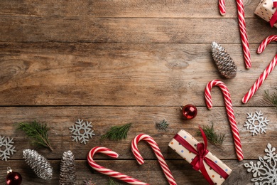Flat lay composition with candy canes and Christmas decor on wooden background. Space for text Photo of Flat lay composition with candy canes and Christmas decor on wooden background. Space for text