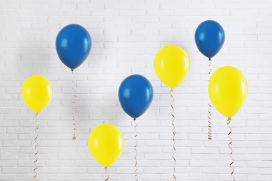 Many balloons in colors of Ukrainian flag near white brick wall Image of Many balloons in colors of Ukrainian flag near white brick wall