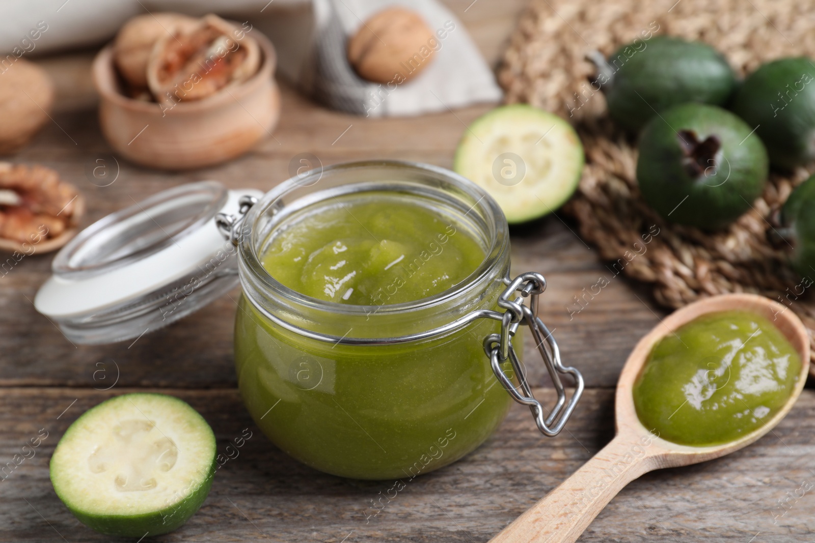 Glass jar of tasty feijoa jam on wooden table, closeup Photo of Glass jar of tasty feijoa jam on wooden table, closeup