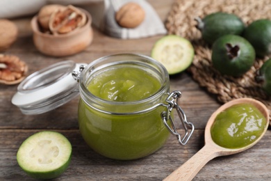 Glass jar of tasty feijoa jam on wooden table, closeup Photo of Glass jar of tasty feijoa jam on wooden table, closeup