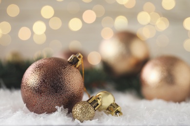 Beautiful Christmas balls on snow against blurred festive lights. Space for text Photo of Beautiful Christmas balls on snow against blurred festive lights. Space for text
