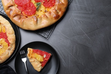 Tasty galette with citrus fruits on grey table, flat lay. Space for text Photo of Tasty galette with citrus fruits on grey table, flat lay. Space for text