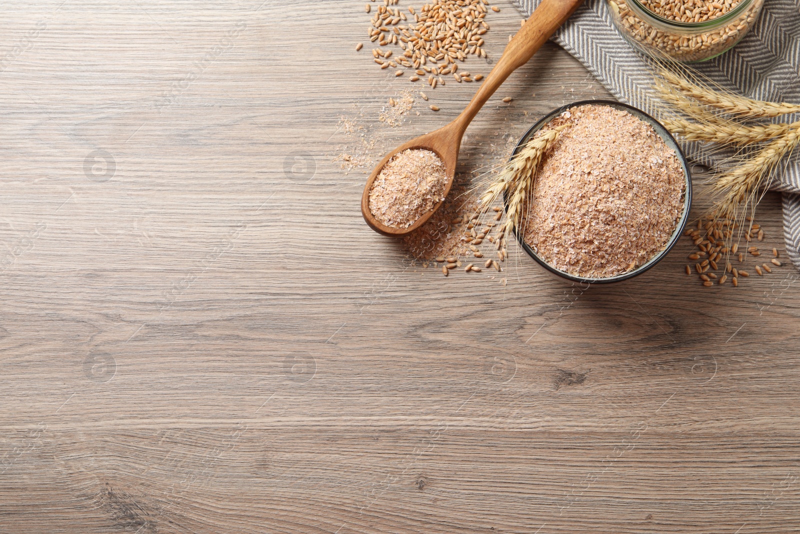 Wheat bran, kernels and spikelets on wooden table, flat lay. Space for text Photo of Wheat bran, kernels and spikelets on wooden table, flat lay. Space for text