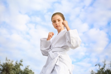 Cute little girl in kimono training karate outdoors Photo of Cute little girl in kimono training karate outdoors