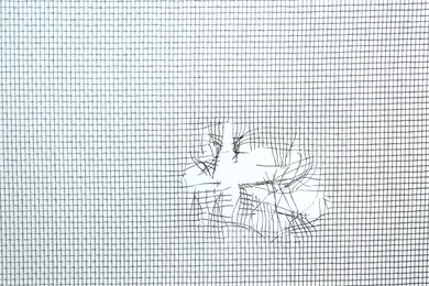 Torn window screen against white background, closeup Photo of Torn window screen against white background, closeup