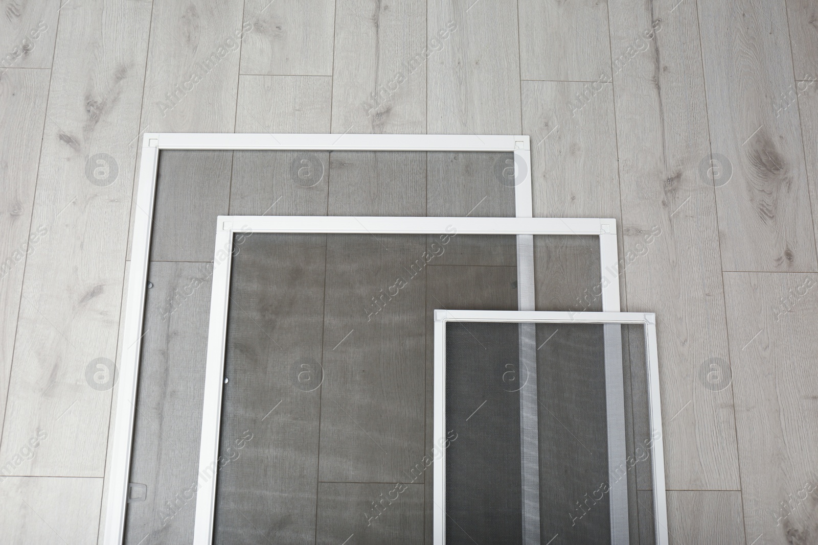Set of window screens on wooden floor, flat lay Photo of Set of window screens on wooden floor, flat lay